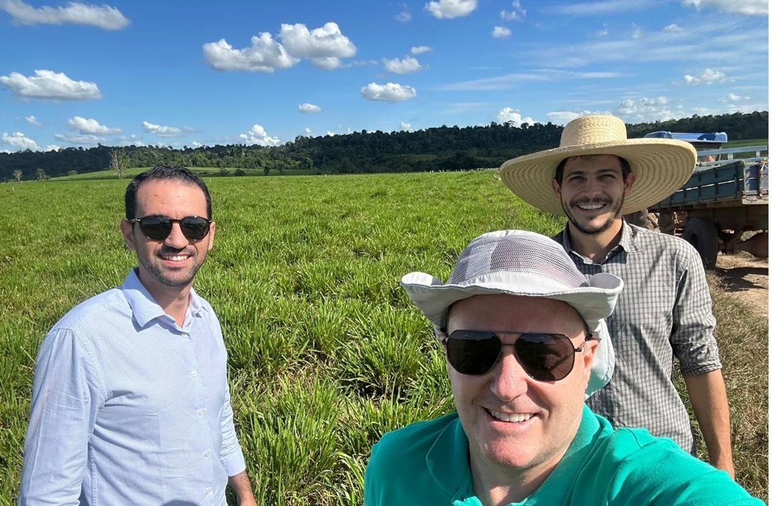 Time técnico da CropWatch ao lado de produtor rural em pastagem no Brasil